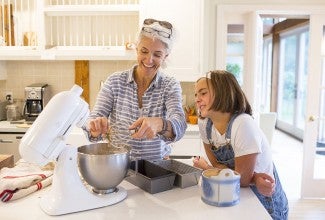Woman and young girl baking together